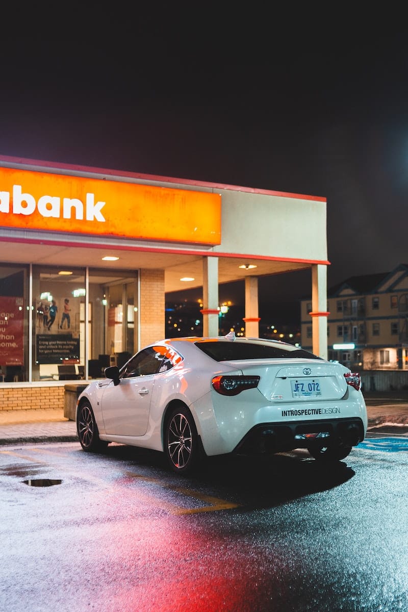 White automobile near bank entrance in nighttime