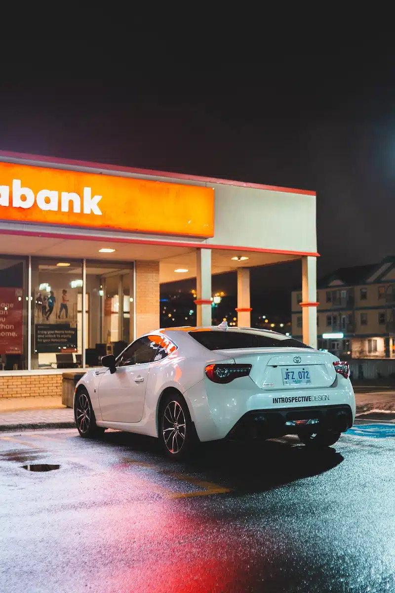 White automobile near bank entrance in nighttime