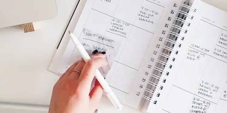 person holding notepad and pen flat lay photography