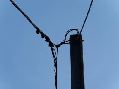 a telephone pole with wires and a blue sky in the background