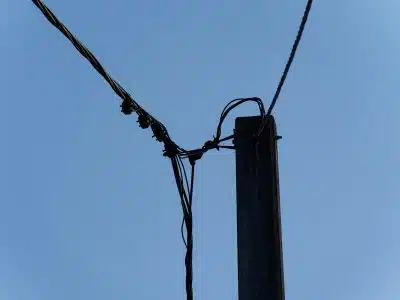 a telephone pole with wires and a blue sky in the background