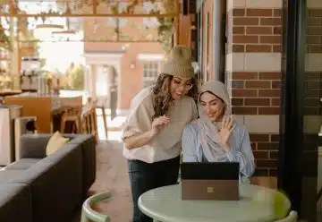 a woman sitting at a table using a laptop